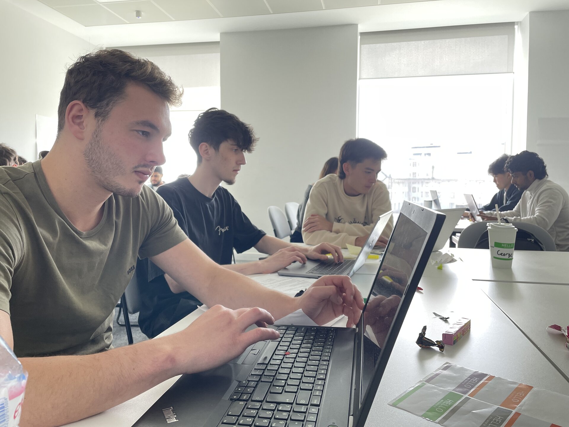 AI Activator participants collaborating on laptops in a workshop