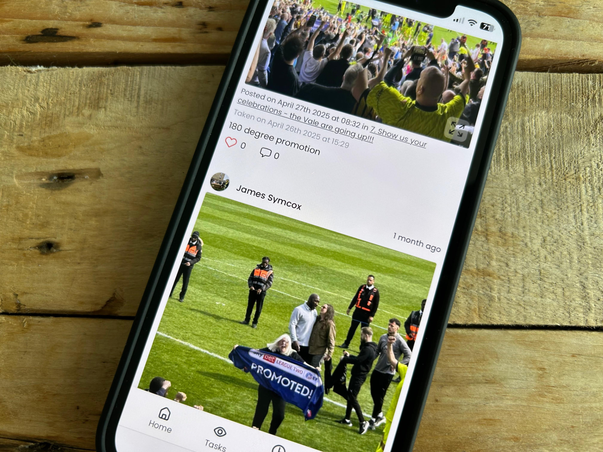 A phone screen showing a crowd-captured photo of a football promotion celebration, illustrating the moments a professional photographer can miss.